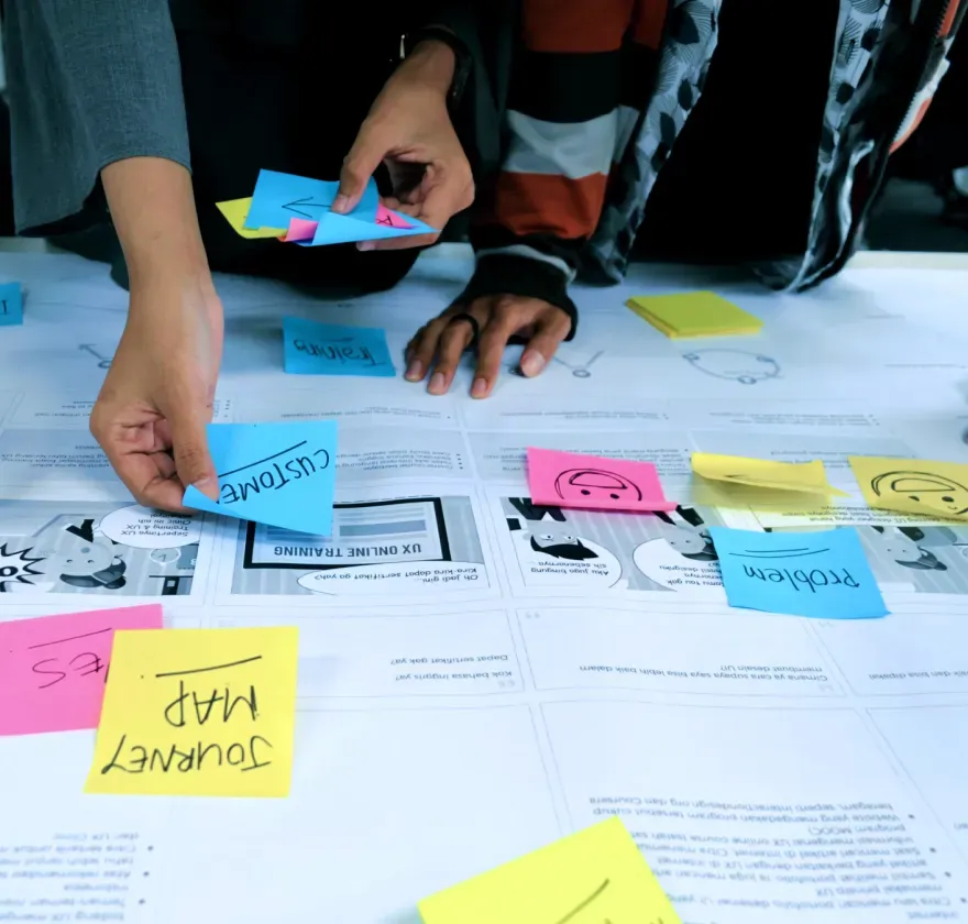 Mahindra Accelo Research Workshop Team arranging sticky notes and interface sketches during the Mahindra Accelo website research process